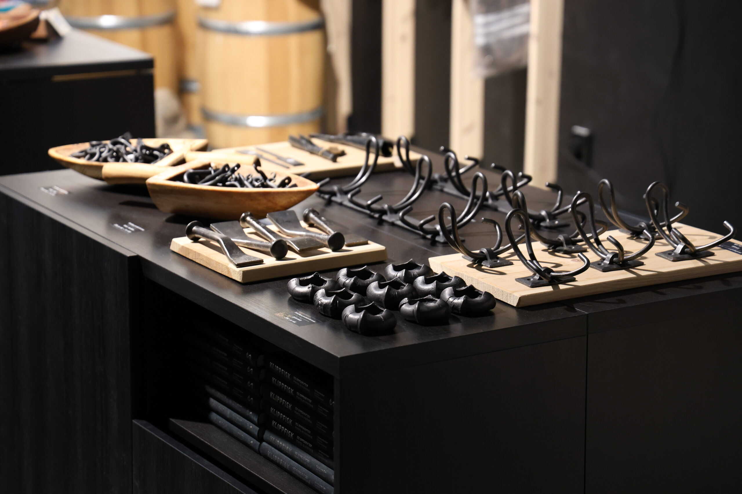 Hand-forged products on a black table – hooks and tealight holders.